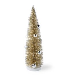 a small gold christmas tree with silver balls on it's top and white base