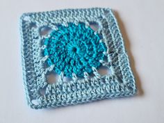 a crocheted square with a blue center