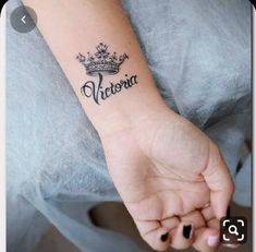 a woman's arm with a tattoo that reads victoria on it and the word victoria written in cursive font