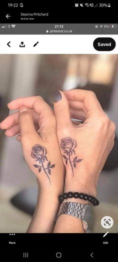 two women with matching tattoos on their hands holding each other's wrists and looking at the camera