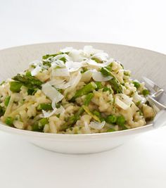 a bowl filled with rice and asparagus on top of a white tablecloth