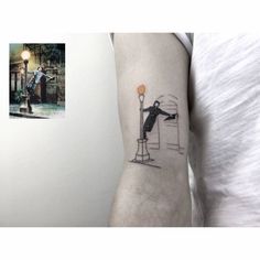 a person with a tattoo on their arm is standing in front of a lamp post