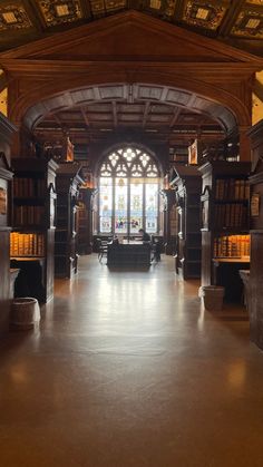 an empty library with lots of books on the shelves and large windows in the ceiling