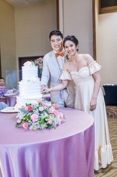 a bride and groom cutting their wedding cake