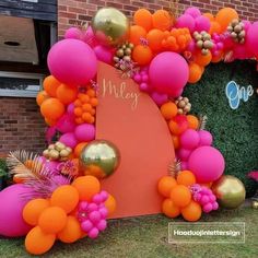 an orange, pink and gold balloon arch