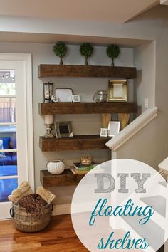 a living room filled with lots of furniture next to a wooden shelf on the wall