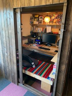 a computer desk sitting in the corner of a room next to a book shelf and bookshelf