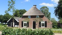 an old brick house with a thatched roof