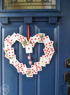 a heart made out of playing cards hangs on the front door's blue door