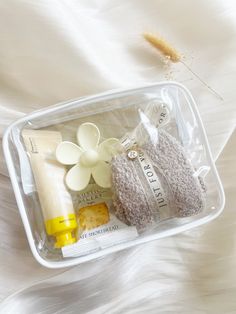 a plastic container filled with bath items on top of a white bed cover covered in fur