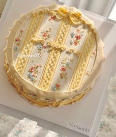 a decorated cake sitting on top of a white box