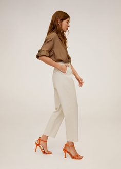 a woman in white pants and brown shirt