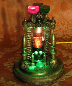 a green and pink light up clock sitting on top of a table