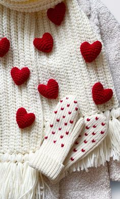 a white sweater with red hearts on it