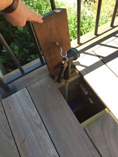 a person is holding an object in their hand while standing on a porch with wooden steps