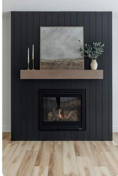 a fireplace with a painting on the mantle and a potted plant next to it