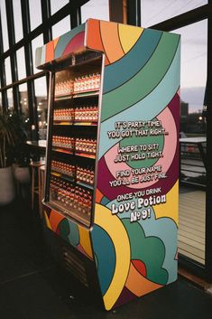 a vending machine with some drinks on it's display shelf in front of a window