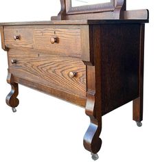 a wooden dresser with a mirror on it's top and two drawers in the middle