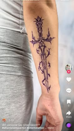 a person with a tattoo on their arm holding a cross in one hand and an arrow in the other