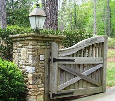 an old stone gate with a lantern on top is surrounded by greenery and trees