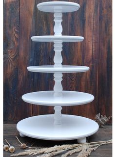 three tiered white cake stand on top of a wooden table