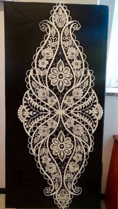 a black and white wall hanging with an intricate design on it's front door