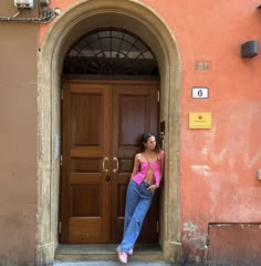 a woman standing in front of a brown door