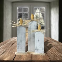 two white vases sitting on top of a wooden table with birds perched on them