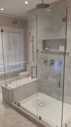 a bathroom with a walk in shower next to a toilet