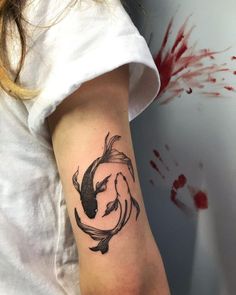 a woman's arm with a koi fish tattoo on it