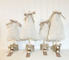 three crocheted bell ornaments with tags on them