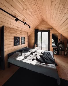 an attic bedroom with wood walls and flooring