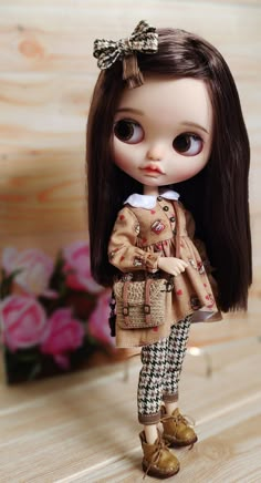 a doll is standing on a wooden surface