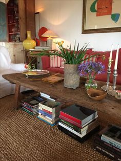 a living room filled with lots of furniture and books on top of a wooden table