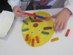 a child is painting a yellow plate with crayons