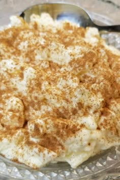 a dessert with cinnamon on top in a glass bowl next to a spoon and fork