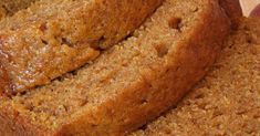 two slices of banana bread sitting on top of a cutting board next to an apple