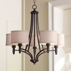 a chandelier with four lamps hanging from it's center and three shades on the bottom