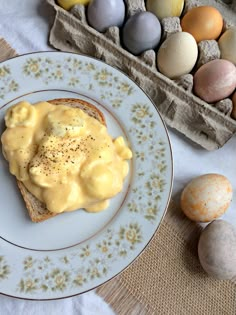 a plate with eggs and cheese on it next to an egg carton