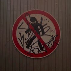 a no entry sign on the side of a building with graffiti written all over it