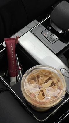 a glass container filled with liquid sitting on top of a stove next to a tube of toothpaste