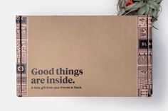 an open box with the words good things are inside on it next to a plant