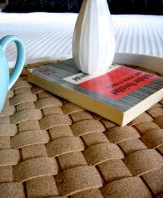 a white vase sitting on top of a book next to a blue watering can,