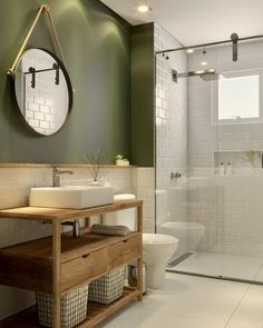 a bathroom with green walls and white tile flooring, along with a wooden vanity