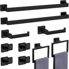 black bathroom accessories including towel holders and towels hanging on the wall, all in different shapes and sizes