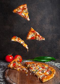 several slices of pizza are being tossed into the air with peppers, tomatoes and jalapenos