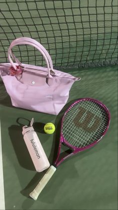 a tennis racket, water bottle and bag on the court