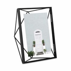 a black frame with a white door and potted plants