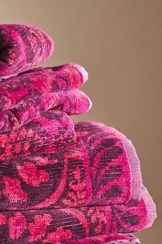 a pile of pink and red rugs stacked on top of each other