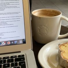 a laptop computer sitting on top of a table next to a cup of coffee